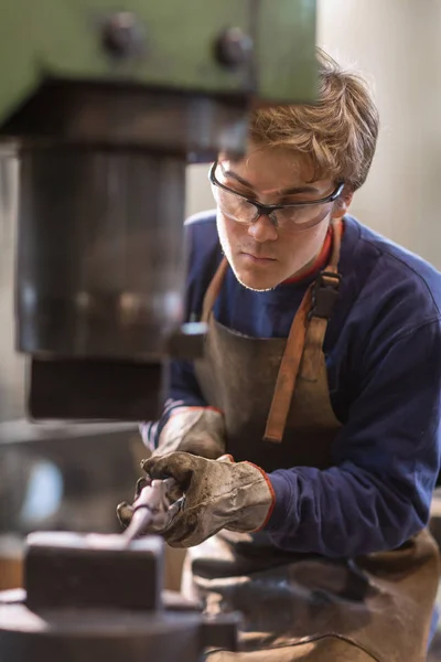 Joven Metalúrgico Herrero Trabajando Con Metal Caliente Taller Que Sostiene — Foto de Stock