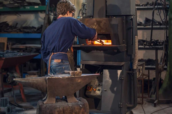 Young Blaksmith Working Metalworking Workshop Holding Set Tongs Burning Furnace — Stock Photo, Image