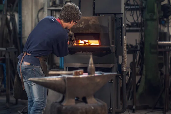 Joven Herrero Trabajando Taller Metalurgia Sosteniendo Conjunto Pinzas Horno Combustión — Foto de Stock