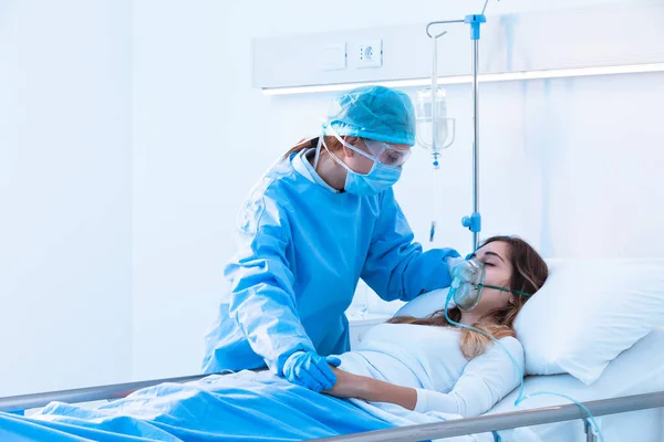 간호사는 병실에서 침대에 호흡기 질환으로 긍정적 산소를 마스크를 환자를 — 스톡 사진