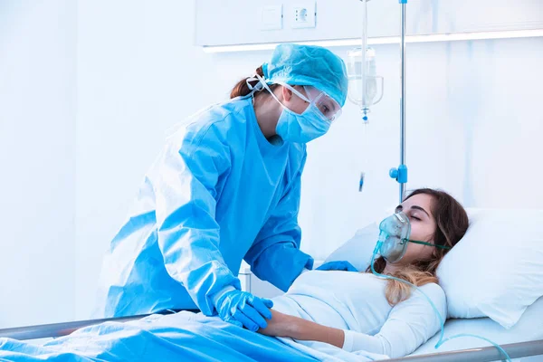간호사는 병실에서 침대에 호흡기 질환으로 긍정적 산소를 마스크를 환자를 — 스톡 사진