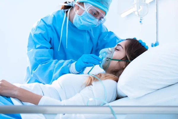 간호사는 코로나 바이러스가 유행하는 병실에 환자의 마스크를 긍정적으로 — 스톡 사진