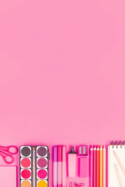 Office or School stationary on pink paper background with copy space; Top view
