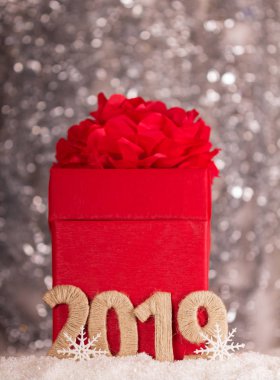 Hediyeler ve 2019 imza bokeh etkisi ile gri arka plan üzerinde kırmızı yılbaşı kutusu