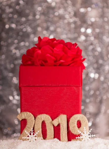 Hediyeler ve 2019 imza bokeh etkisi ile gri arka plan üzerinde kırmızı yılbaşı kutusu