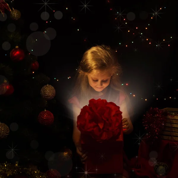 クリスマスの組成物 新年のツリーで小さな女の子は 魔法のボックスを開く — ストック写真