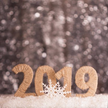 Kar bokeh etkisi ile parlak gri arka plan üzerinde yazıt 2019 yeni yılda
