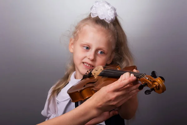 Красивая Маленькая Девочка Играет Скрипке Ярко Сером Фоне — стоковое фото