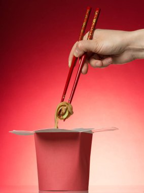 Parlak arka plan üzerinde kırmızı bir kutu içinde lezzetli Çin eriştesi