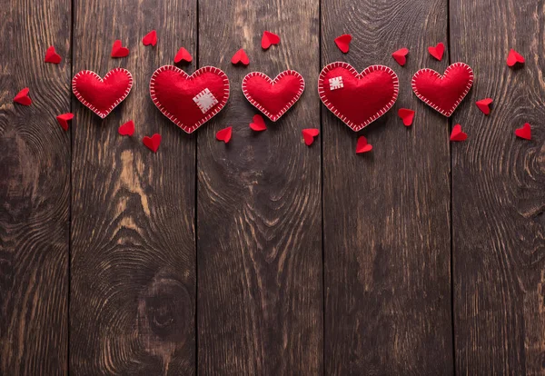 Coração de feltro vermelho brilhante feito à mão em tábuas de madeira — Fotografia de Stock