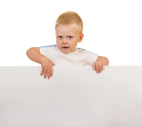 Lächelnder kleiner Junge mit stechenden Augen hinter einem weißen leeren Banner — Stockfoto