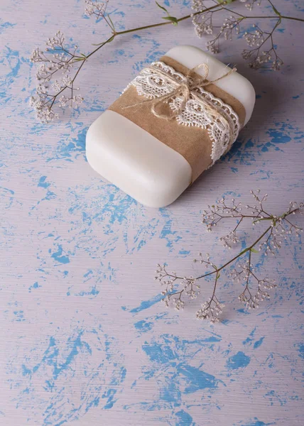 Jabón floral blanco hecho a mano de materias primas naturales sobre un azul claro —  Fotos de Stock