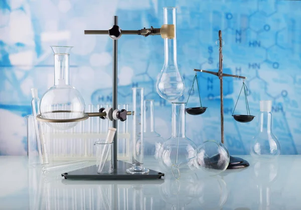 Laborbedingungen. Chemische Waage, Stativ mit Laborkolben und Reagenzgläsern auf blau — Stockfoto