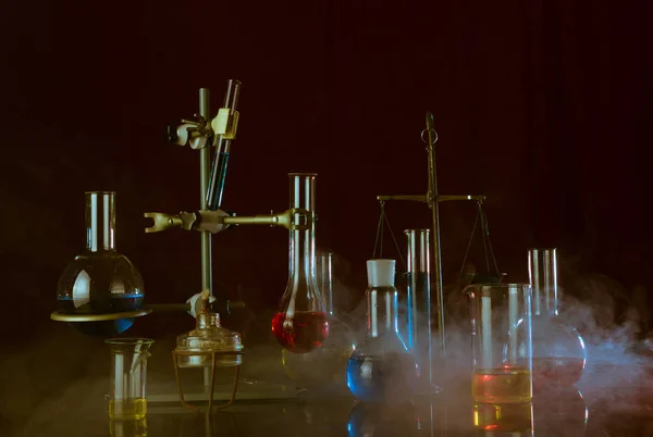 Variedade de vasos de laboratório com reagentes coloridos em uma prateleira. Uma reacção química — Fotografia de Stock