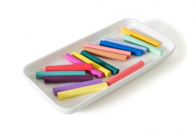 Beyaz arka plan üzerinde izole güzel beyaz plaka renkli tebeşir pastel