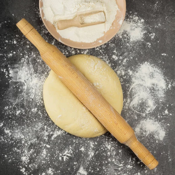 Massa de farinha de levedura delicada de tortas, rolo de pino e farinha em um cinza — Fotografia de Stock