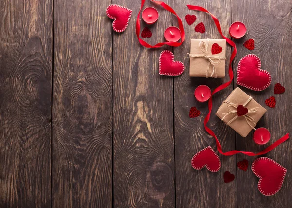 Composizione festiva. Cuori di feltro rosso, scatole fatte a mano su un tavolo di legno — Foto Stock