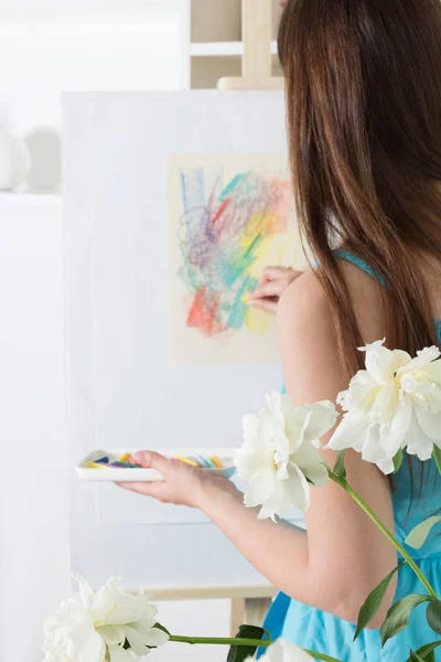 Девушка-художник рисует абстрактную картину мелом пастели на белой бумаге — стоковое фото