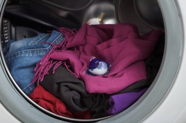 Yıkama kapsülü çamaşır makinesinin varilinde yatıyor. Yakın plan..