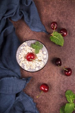 Sağlıklı bir kahvaltı, chia tohumları, yulaf ezmesi ve koyu arkaplanda taze böğürtlenler.