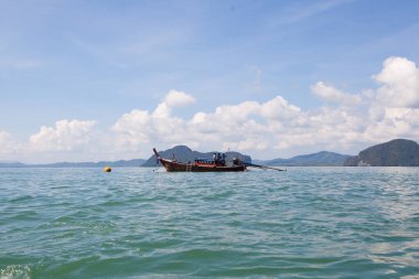 Tropikal denizde kayaların arasında balıkçı teknesi