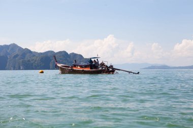 Tropikal denizde kayaların arasında balıkçı teknesi