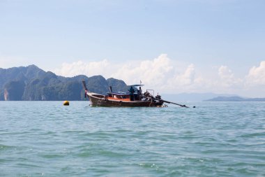 Tropikal denizde kayaların arasında balıkçı teknesi