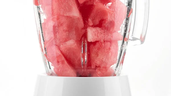 pieces of watermelon in blender for making smoothie. Making watermelon juice. Healthy summer eating concept. Recipe of fresh healthy drink