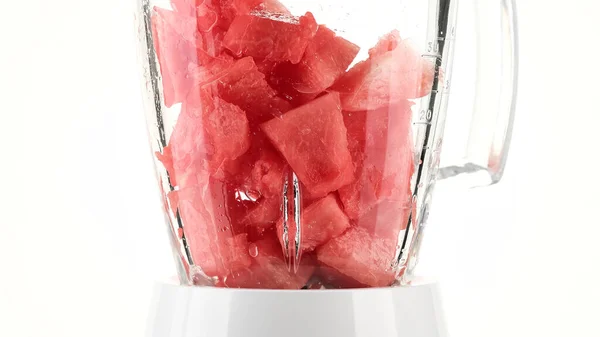 pieces of watermelon in blender for making smoothie. Making watermelon juice. Healthy summer eating concept. Recipe of fresh healthy drink