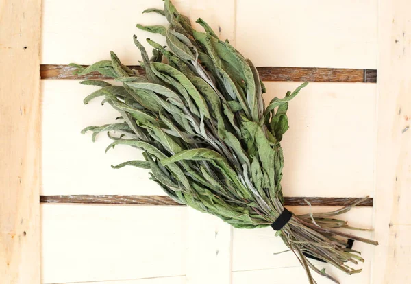 Dried bunch of sage herbs on wooden background. Traditional medicine. Spa settings.