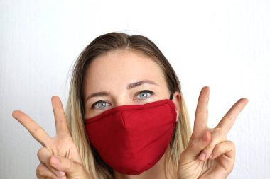 Koronavirüsten korunmak için pamuk bez maskeli genç bir kadın. El yapımı pamuk maske.. 