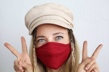 Koronavirüsten korunmak için pamuk bez maskeli genç bir kadın. El yapımı pamuk maske.. 