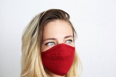 Koronavirüsten korunmak için pamuk bez maskeli genç bir kadın. El yapımı pamuk maske.. 