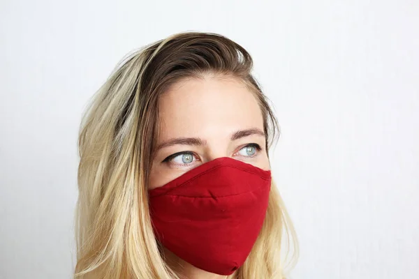 Young woman wearing cotton cloth face mask to protect against coronavirus. Stylish handmade cotton face mask.
