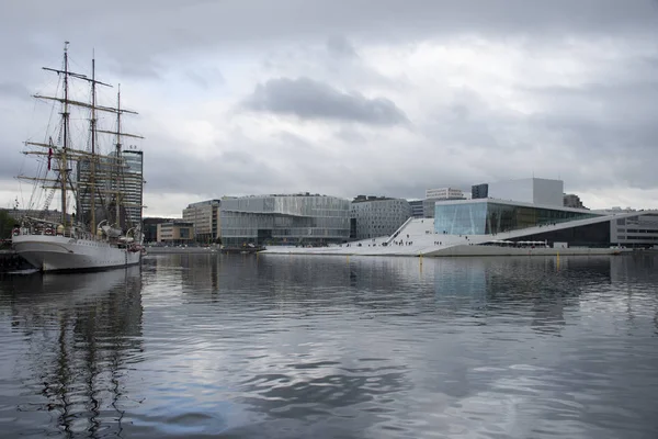 Modern architecture of Oslo on the water under dark clouds