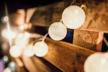 Beautiful closeup shot of lit up indoor string lights hanged up on a wall clipart