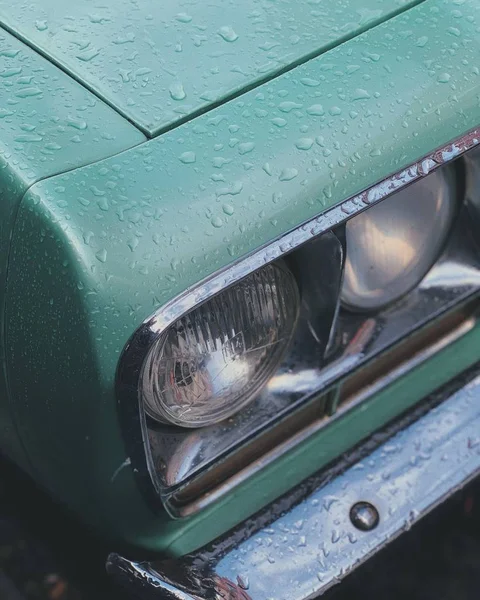 Captură verticală de închidere a farurilor unei mașini verzi — Fotografie, imagine de stoc