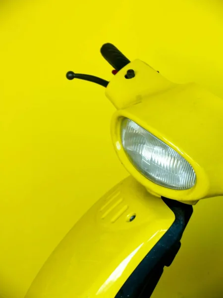 Close up tiro de pegas de scooter e luz frontal com fundo amarelo — Fotografia de Stock