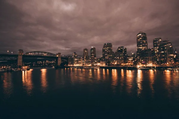 Gyönyörű kép a városról és a folyóról éjszaka. — Stock Fotó