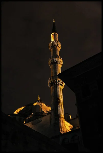 Vue verticale d'une tour de mosquée sous un ciel sombre la nuit — Photo