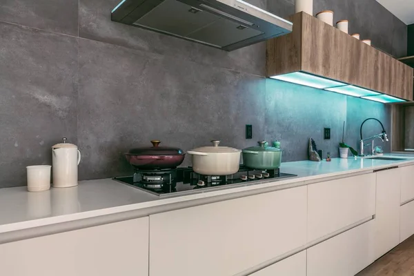 Belo interior de uma cozinha moderna com panelas de cozinha no forno e outros suprimentos de cozinha — Fotografia de Stock