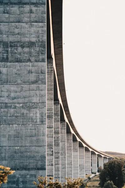 Zijde van een hoge stenen snelweg brug met heldere witte lucht op de achtergrond — Stockfoto