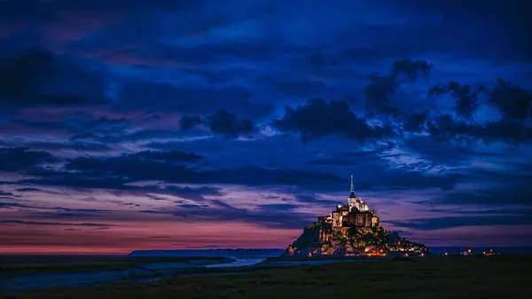 Ευρεία βολή ενός φωτισμένου κάστρου σε απόσταση με εκπληκτικά μπλε σύννεφα στον ουρανό — Φωτογραφία Αρχείου
