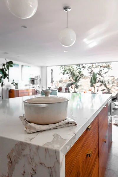 Belo interior de cozinha moderna com um pote de metal branco na mesa — Fotografia de Stock