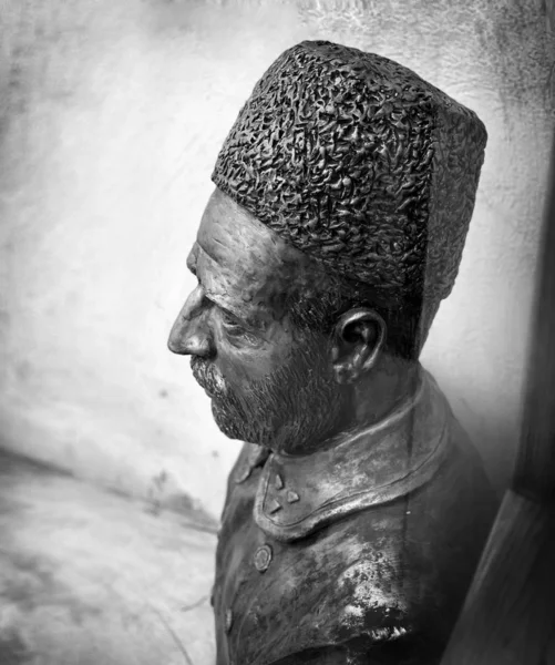 Close-up van een mannelijk metalen standbeeld met een hoed en een baard in zwart-wit — Stockfoto