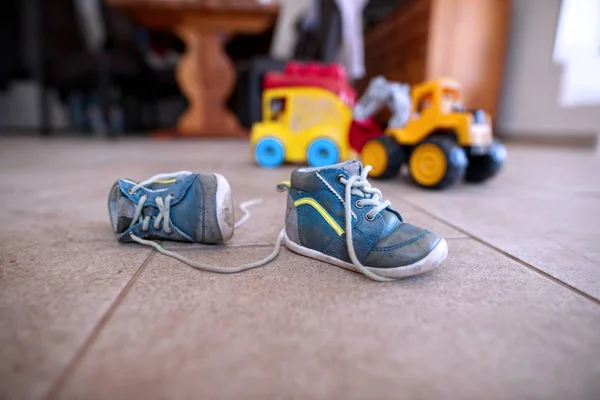 Closeup tiro de tênis pequeno bebê azul com um brinquedo no fundo — Fotografia de Stock