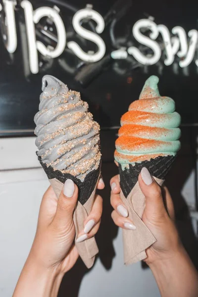 Hands holding two tasty looking  cie creams in dark brown cones — Stock Photo, Image
