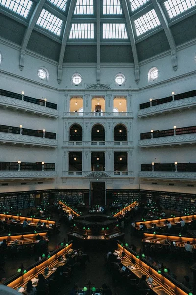 Belo interior de uma grande biblioteca com pessoas trabalhando em laptops — Fotografia de Stock