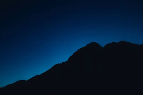 Krásná noční obloha za tmavými kopci — Stock fotografie