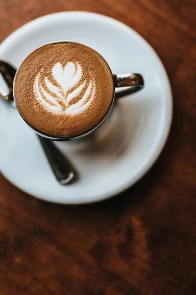 Prachtig gemaakte cappuccino geserveerd met bloemsierkunst op de Foam shot van bovenaanzicht — Stockfoto